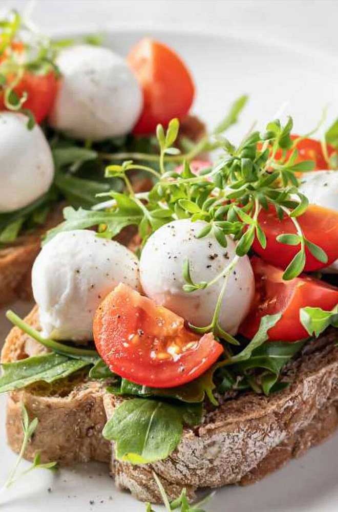 Mozzarella mit frischen Tomaten und Rucola auf Vollkornbrot