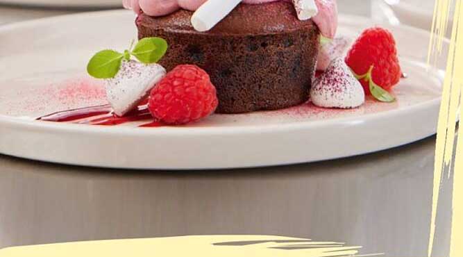 Feiner Schokoladenkuchen mit Himbeeren und Sahne